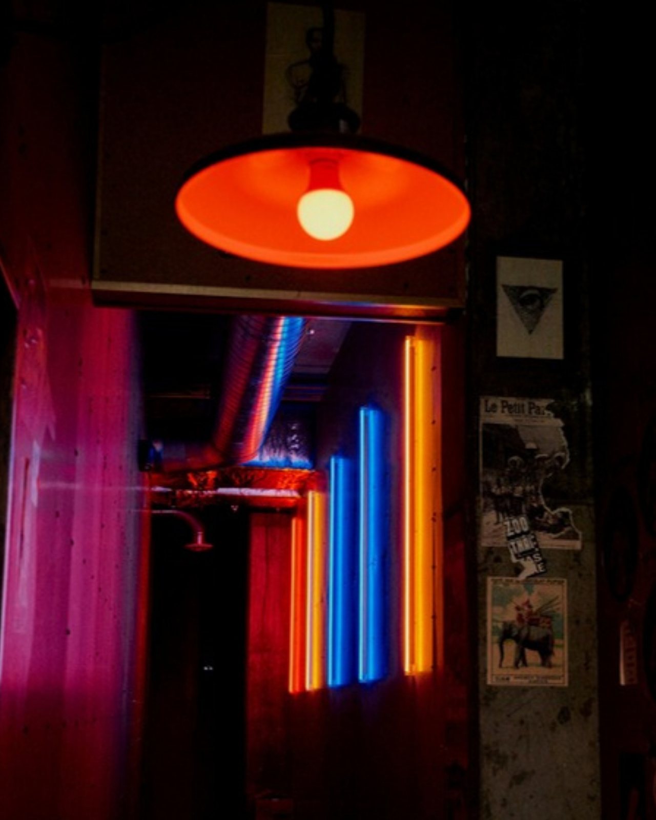 The Zoo Thai entry: a red pendant lamp over a dark hallway lit by vertical pink, blue and orange neon tubes